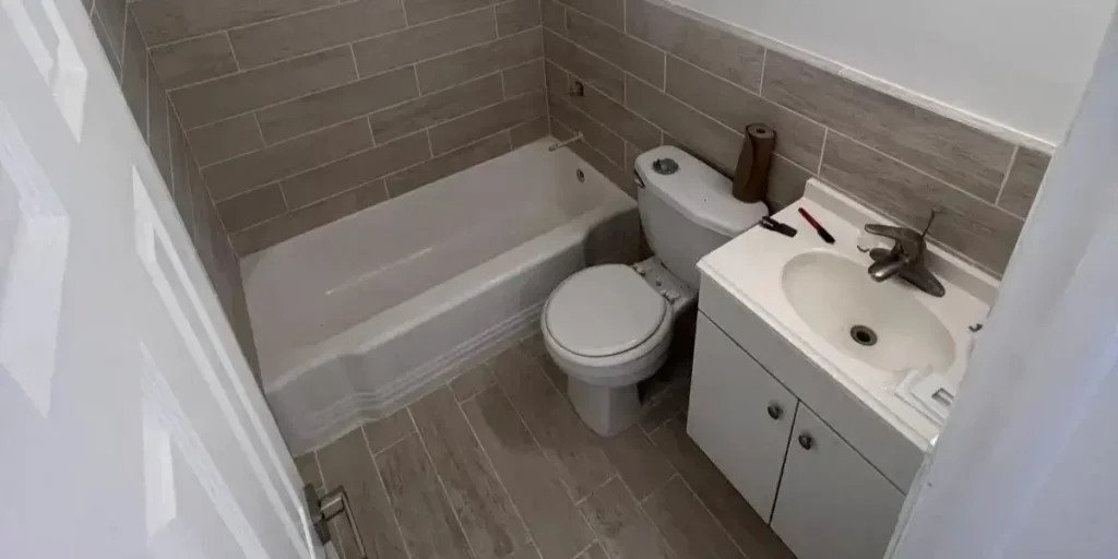 Modern remodeled bathroom with new tiles, tub, and vanity in Miami.