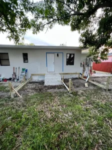Backyard area before deck construction with white concrete steps and wood framing - Miami