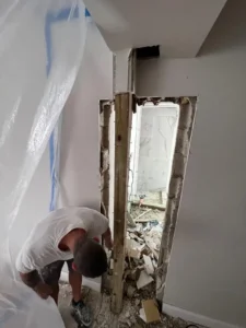 Removing wall during laundry to bathroom construction in Miami
